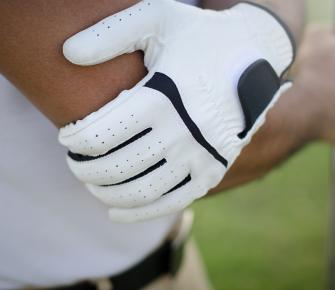 golfer holding elbow in pain